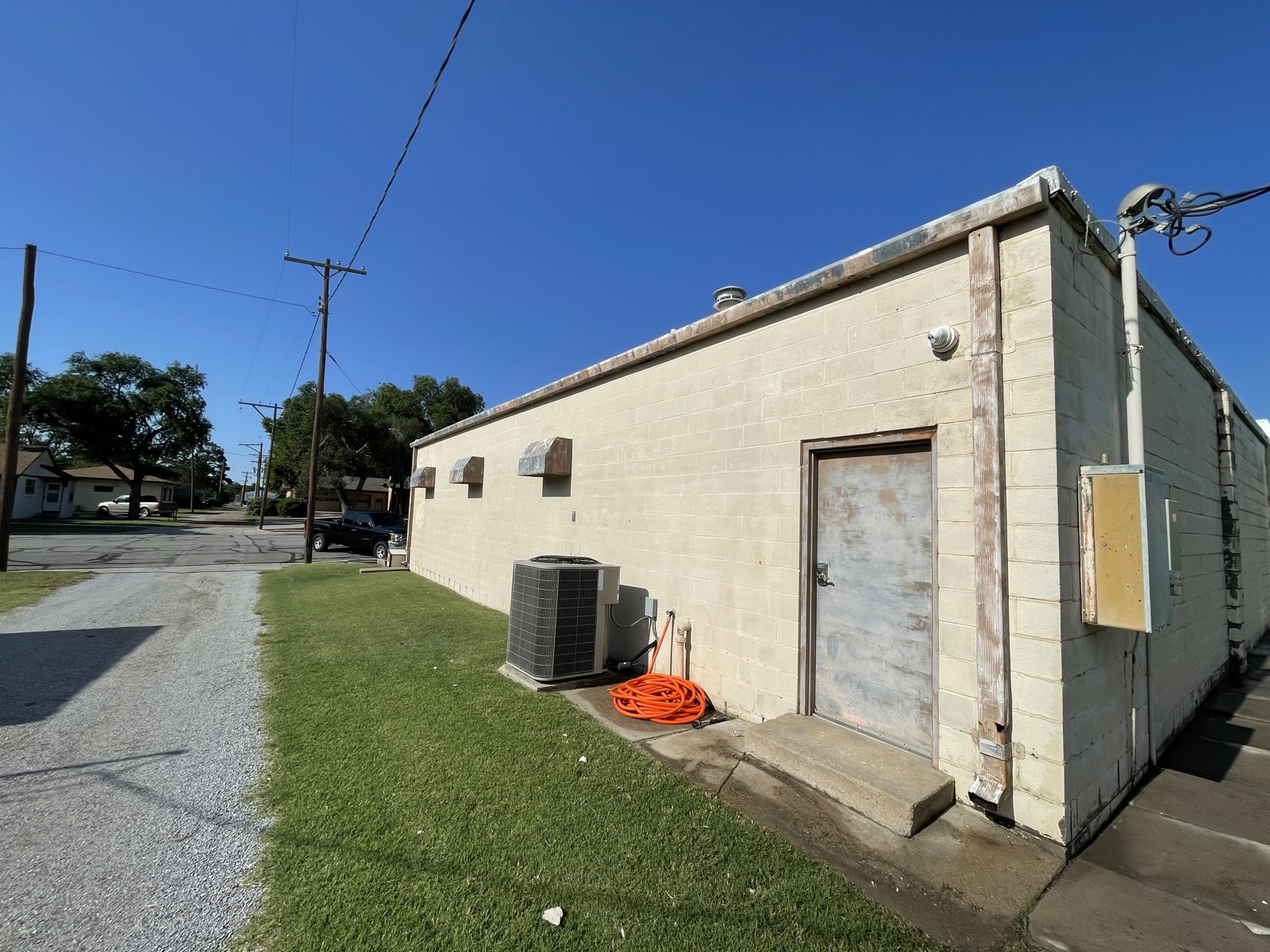 Before: faded cream cinder-block commercial building