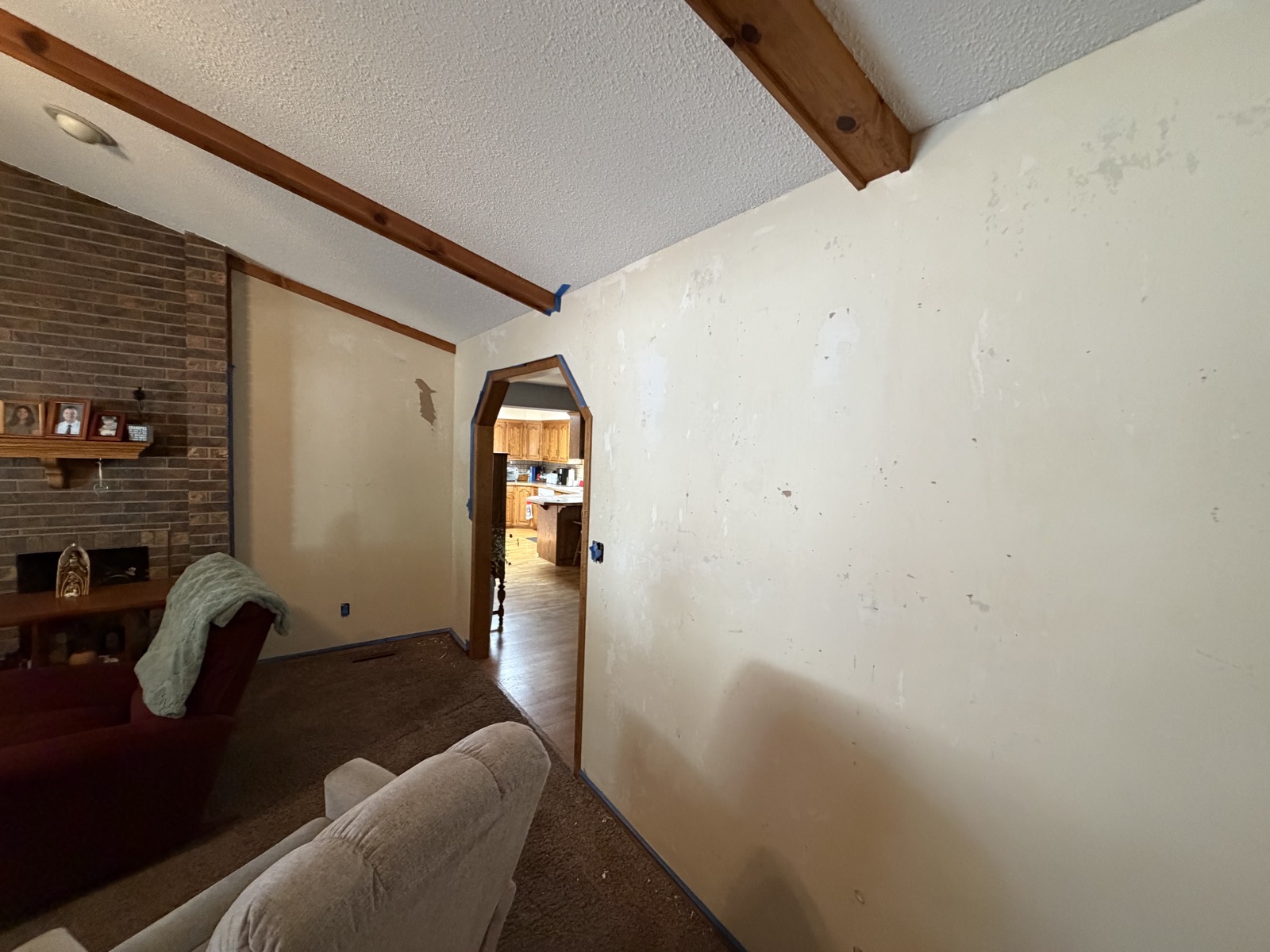 Before: living room wall with drywall patches and damage
