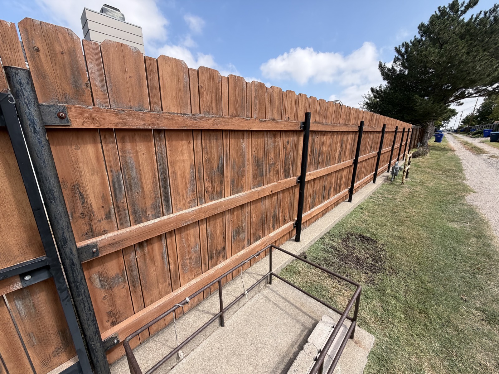 Before: weathered, graying privacy fence