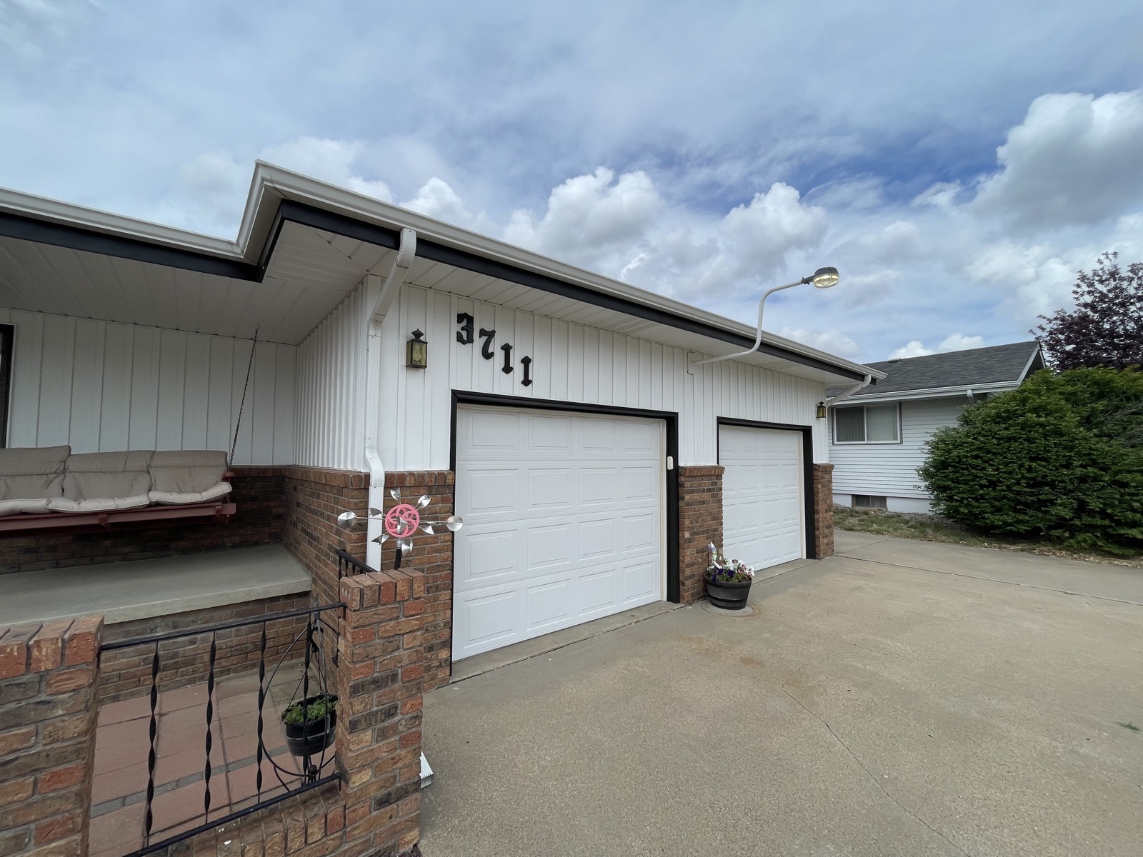 After: freshly repainted white exterior and garage front in Hays, Kansas