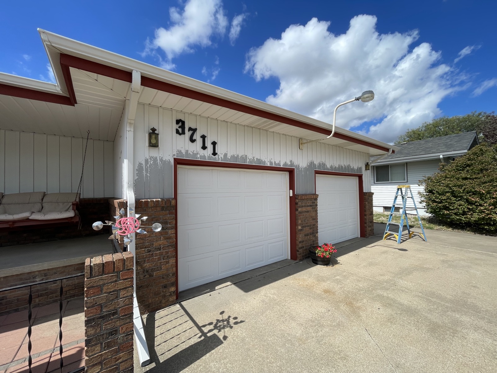 Before: peeling, faded paint above the garage doors