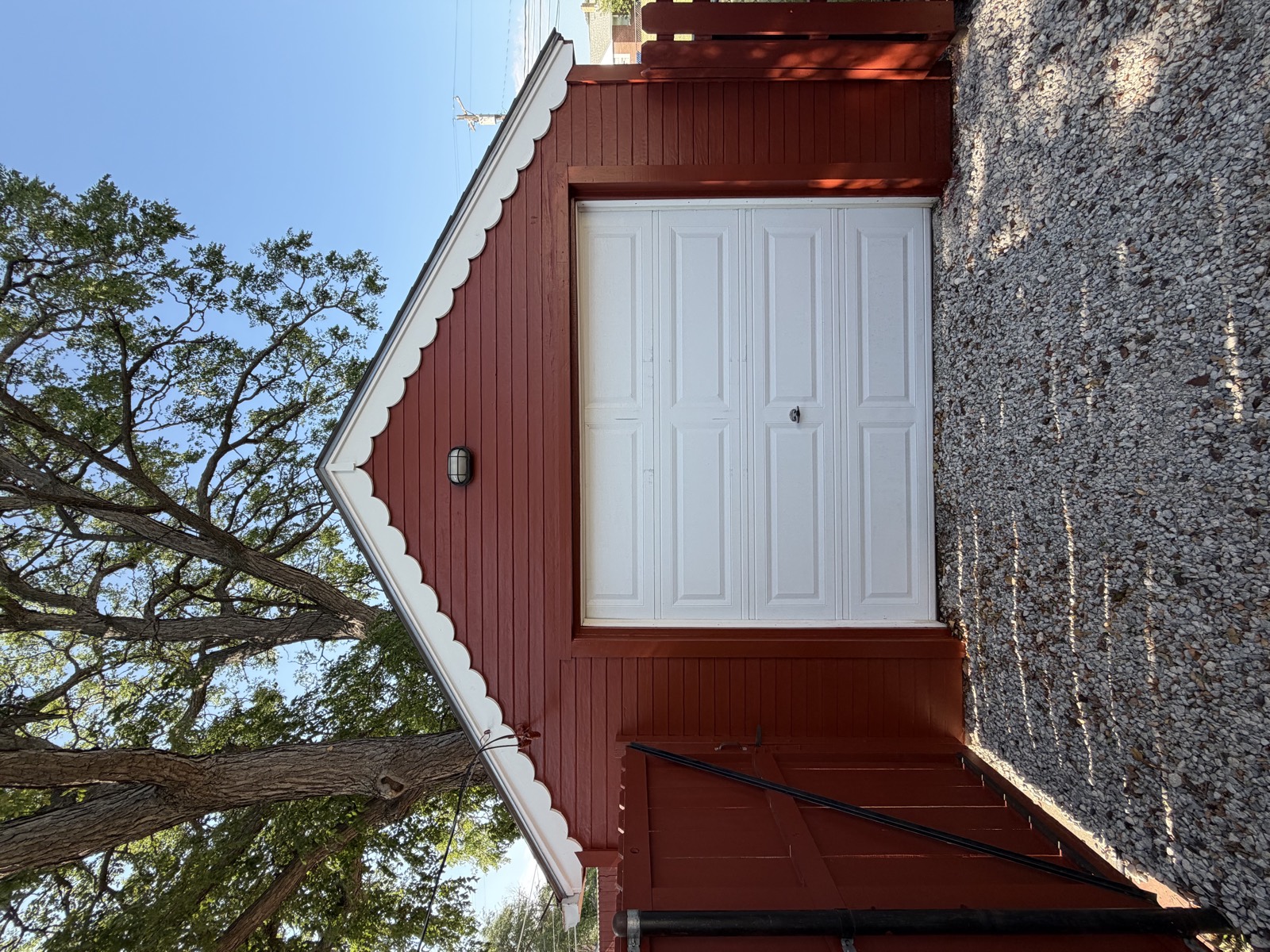 After: detached garage repainted bright red with crisp white trim