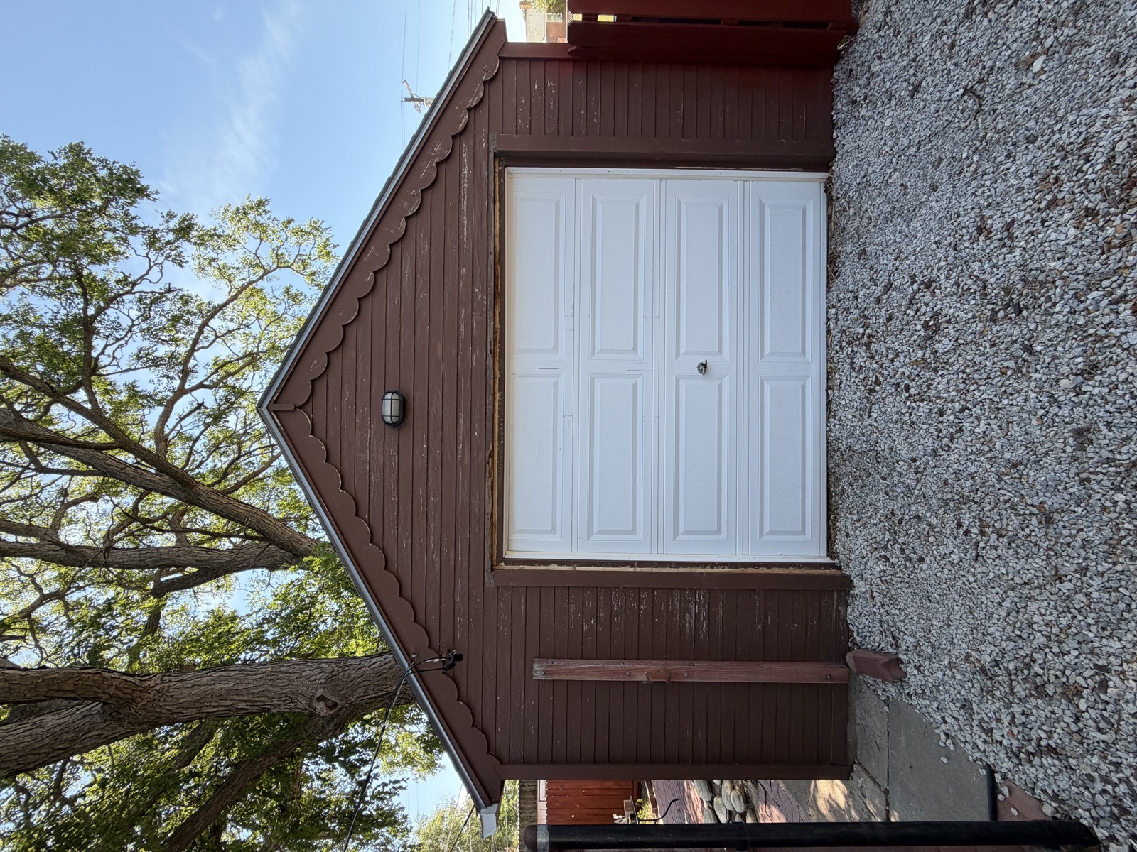 Before: detached garage with faded brown paint and peeling trim