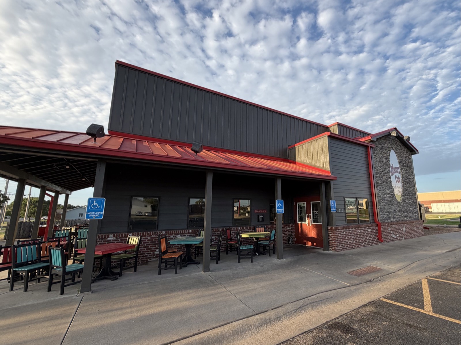 After: restaurant exterior repainted dark bronze with red roof accents