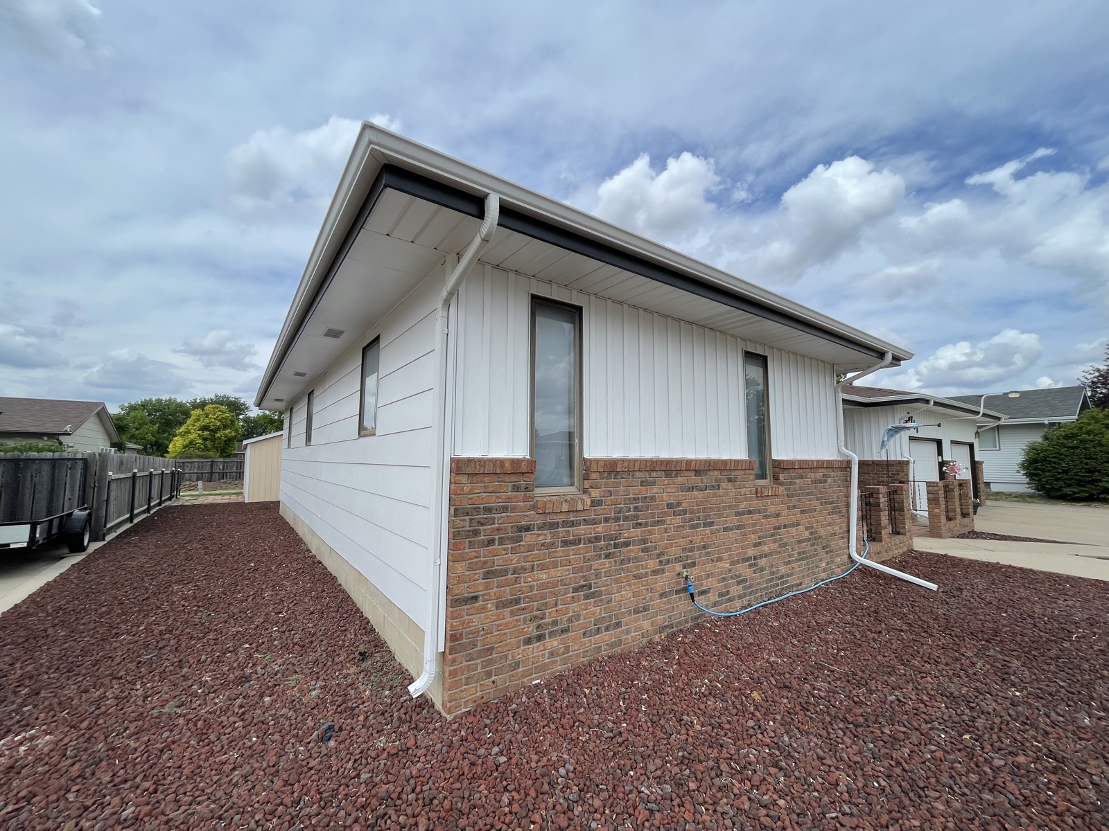 After: bright white repainted siding above brick
